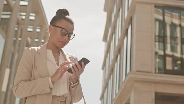 Mixed-Race Businesswoman with Smartphone Outdoors