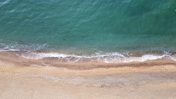 Top view of empty and clean beach and waves of blue sea with clear water.