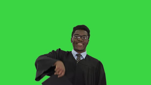 Excited African American Male Student Throwing Mortarboard in the Air and Making Silly Dance