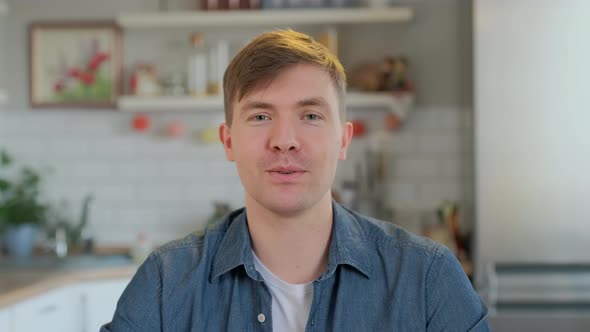 Head shot close up young handsome man looking at camera, talking to friends. Motivated male job