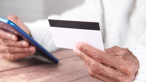 Senior Women Hand Holding Credit Card and Using Smart Phone Shopping Online