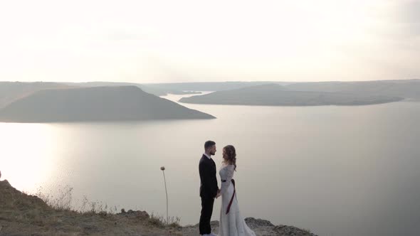 A Man and a Woman Are Standing on the Edge of the Cliff Near the Ocean