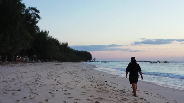 Woman tans on exotic tourist beach wildlife by blue water with white sand background of the Maldives