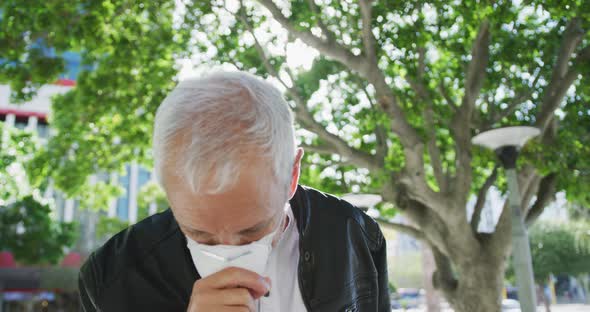 Caucasian man out and about in the street wearing on a face mask against coronavirus