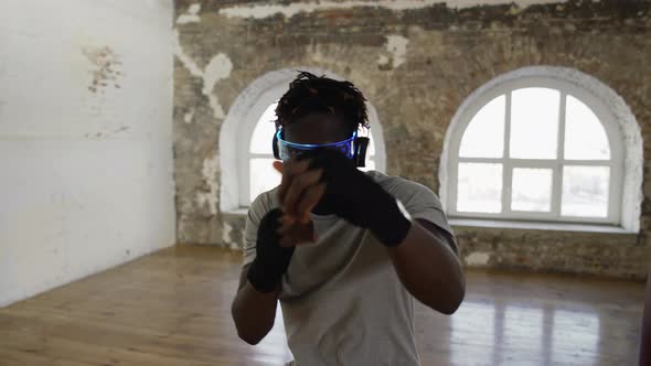 Young Male Boxer Practicing Shadow Boxing in Light Sport Studio