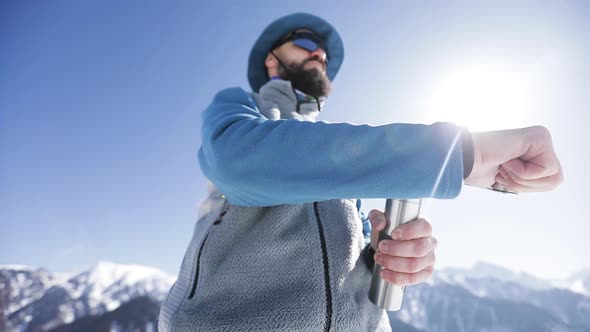 Man with Hand Coffee Grinder in the Winter Mountains