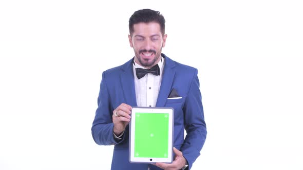 Happy Young Bearded Businessman Showing Digital Tablet and Looking Surprised