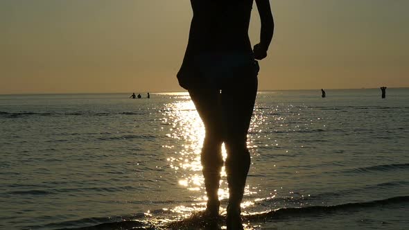 Young Woman Runs Into The Sea In Sun Flare Water, Girl Silhouette Running Into The Sea