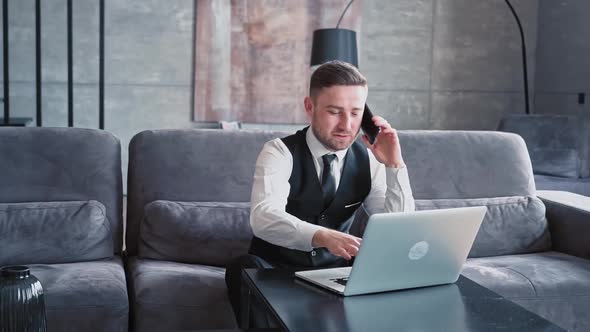 A Professional Sits in a Beautiful Dark Office in Front of a Laptop