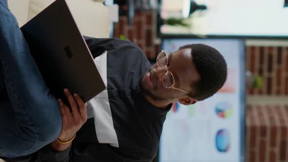 Vertical Video Portrait of Company Employee Working on Laptop Computer