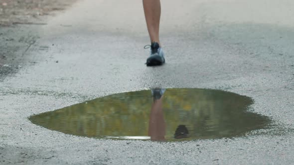 Runner Man Fit Athlete Legs Jogging On Trail Ready To Triathlon. Running Man On Puddle. Workout.