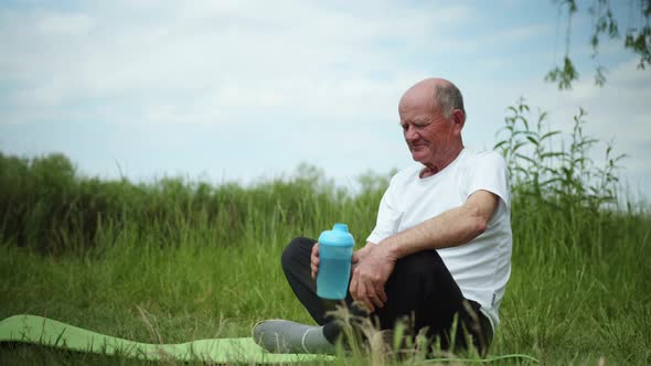 Healthy Eating, Elderly Man Leads Healthy Lifestyle and Drinks Clean Water in Sports Bottle After