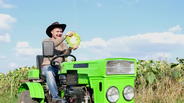 Happy Farmer Laughs While Sitting on His Green Tractor