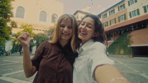 Two Young Smiling Girls Take Selfie Photos on a Smartphone