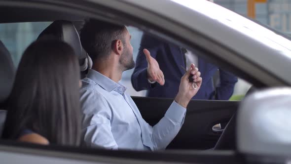 Joyful Couple Taking Keys While Sitting in New Car