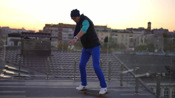 Wide Shot Adult Man Training Skateboarding on Roof in Urban City Riding to Camera Leaving