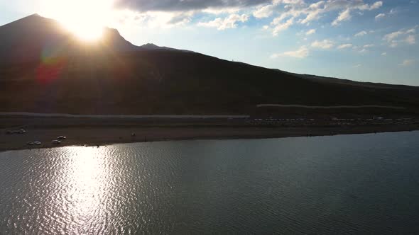 Aerial View From Behind ATVs by Lake and Mountain