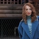 Young Redhaired Woman in a Blue Coat and Walks Against the Backdrop of the Old City - VideoHive Item for Sale