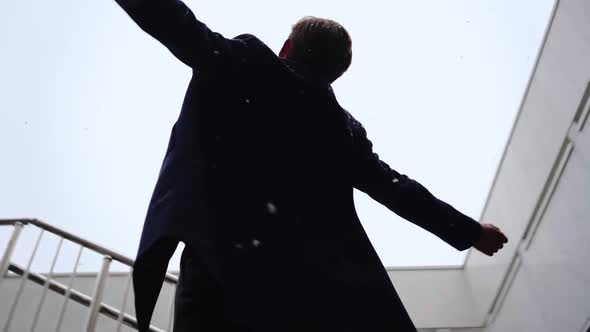 Successful Businessman with Raised Hands Celebrating His Victory During Snowfall