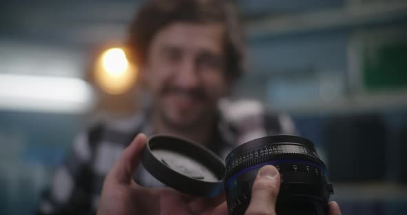 Costumer Holding Lens in Video Equipment Store