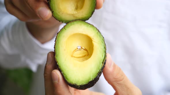 Man Holding Avocado With Engagement Ring To Propose Marriage