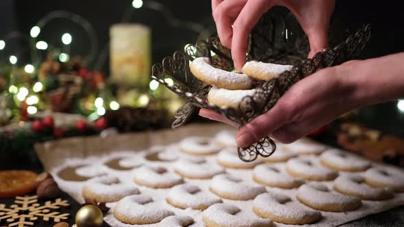 Woman Puts Traditional German or Austrian Vanillekipferl Vanilla Kipferl Cookies in a Basket