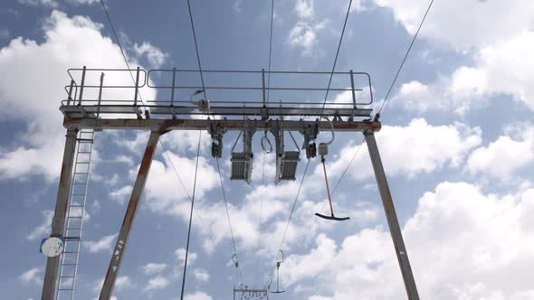 Pan up of the lift line of les Deux Alpes in France. In the background the sky full of clouds