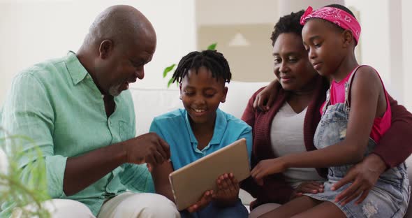 African american grandparents and grandchildren using digital tablet at home