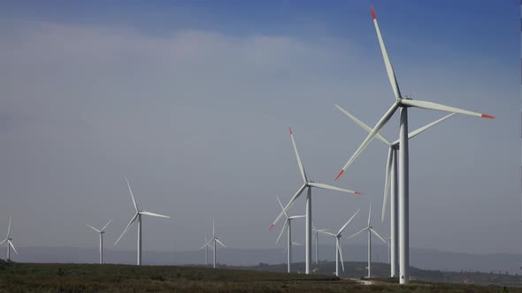 Windmills or Wind Turbine on Wind Farm in Rotation