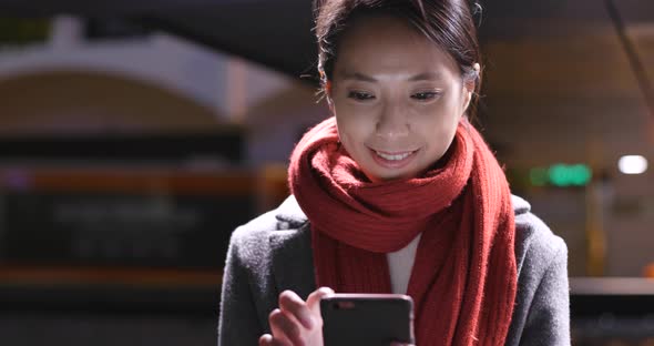 Young Woman use of smart phone in city at night