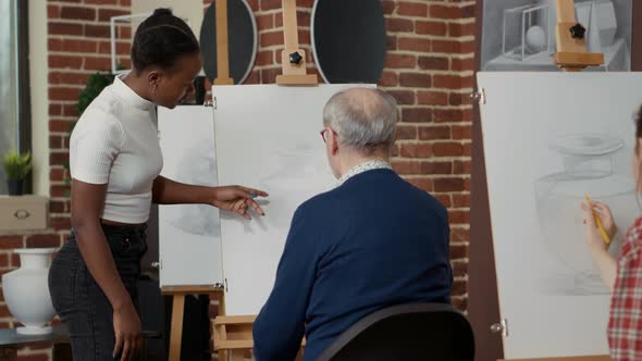 African American Teacher Explaining Drawing Technique to Old Student