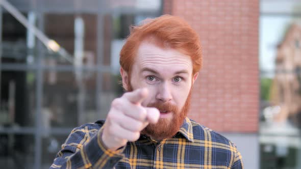 Redhead Man Pointing with Finger Outdoor