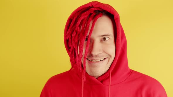 Young Man with Red Dreadlocks in Hood Grimacing Face