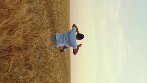 Vertical Screen Dad Spinning Around Little Son in Field in Slow Motion