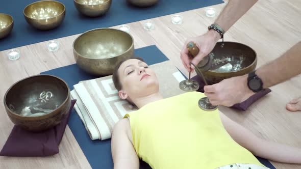 Woman Practicing Yoga Meditation with Singing Bowl