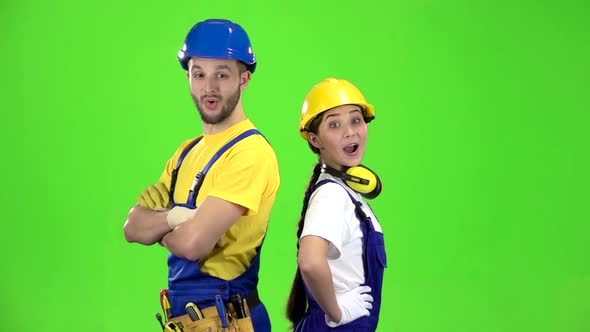 Builders of the Guy with the Girl Touting the Product and Show Their Thumbs Up. Green Screen. Slow