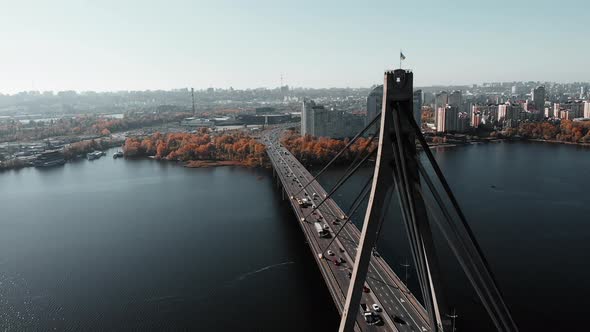 Ukrainian Flag Waving on Bridge Connecting Two Banks of Metropolis with Heavy Traffic
