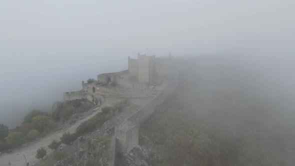 Slow pan around the castle walls disappearing into the mist around Marvão Castle