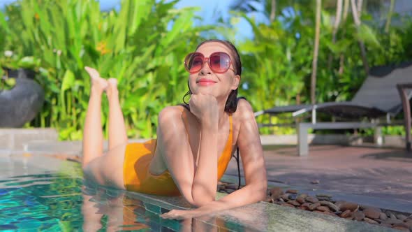 Young asian woman enjoy around outdoor swimming pool for leisure