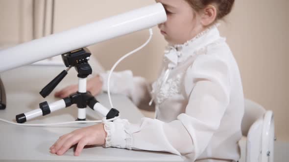 Portrait of a Child Who Looks in an Ophthalmological Tube for Eye Examination