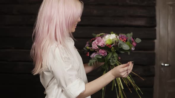 A Pink Haired Young Woman Makes the Design of the Bouquet Complementing the Composition with Willow