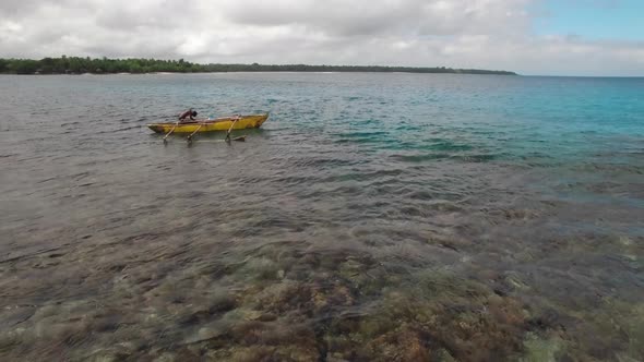 Static Aerial View on Local Fisherman Boat With Outrigger in Shallow Water of Tropical Sea