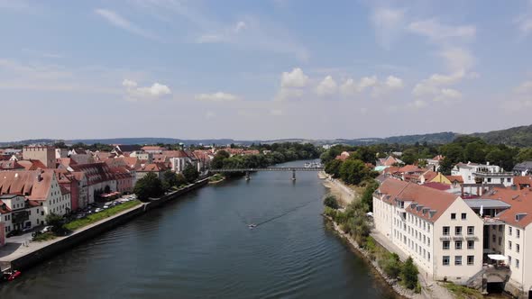 Aerial flyover above of Danube river, Regensburg cityscape, European tourist city, Zoom in