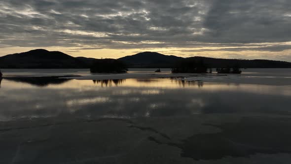 Beautiful golden hour sunset beyond frozen lake in Winter