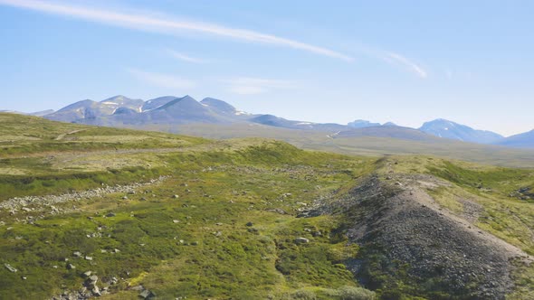 Rocky Green Fields With Mountains And Blue Sky In The Background In Rondane National Park, Norway. -