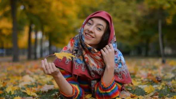 Beautiful and Happy Russian Girl Smiling Portrait in Autumn Park Lies