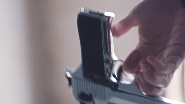 A Man Spinning a Steel Gun in His Hand Around His Finger