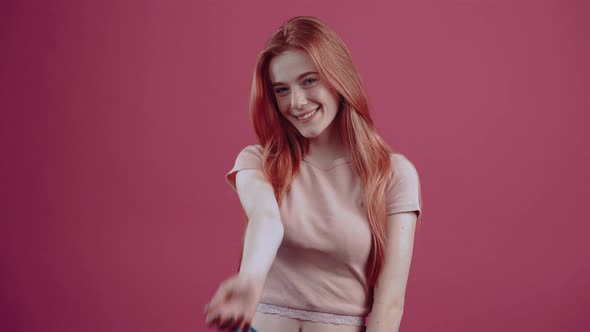 Loving Excited Young Redhead Shares Kisses with Her Hand Smiling Sincerely at the Room