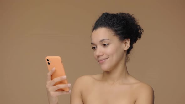 Beauty Portrait of Young African American Woman Texting on a Smartphone and Rejoice