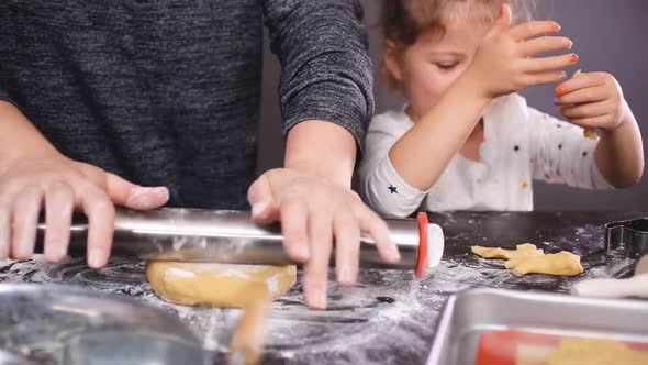 Mother and daughter baking sugar skull cookies for Dia de los Muertos holiday.